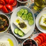 Mediterranean table spread with feta cheese, vegetables, and olives